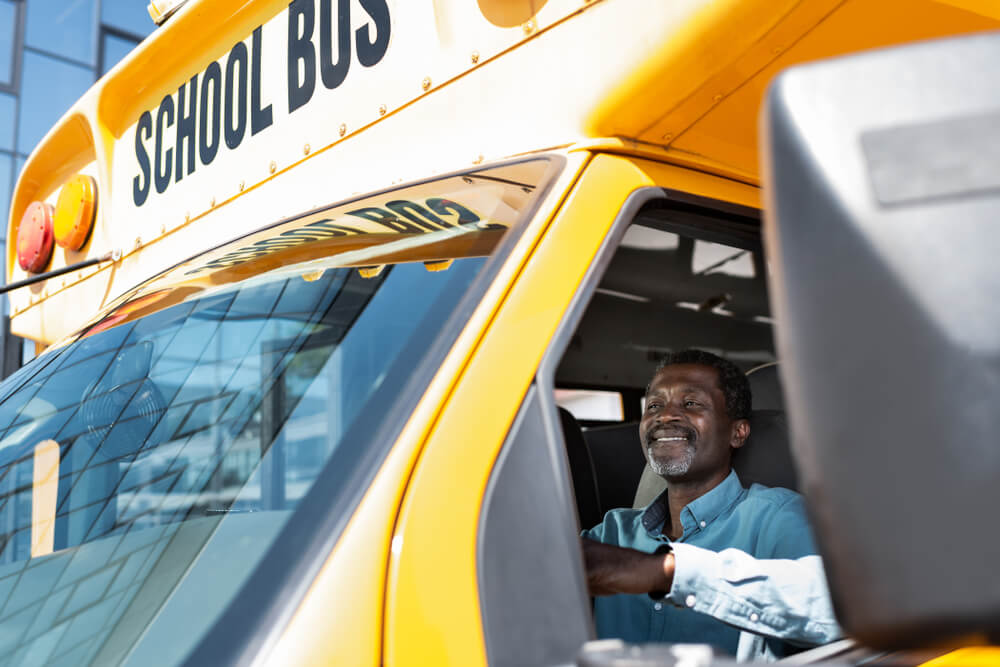 View through side window at mature african american bus driver