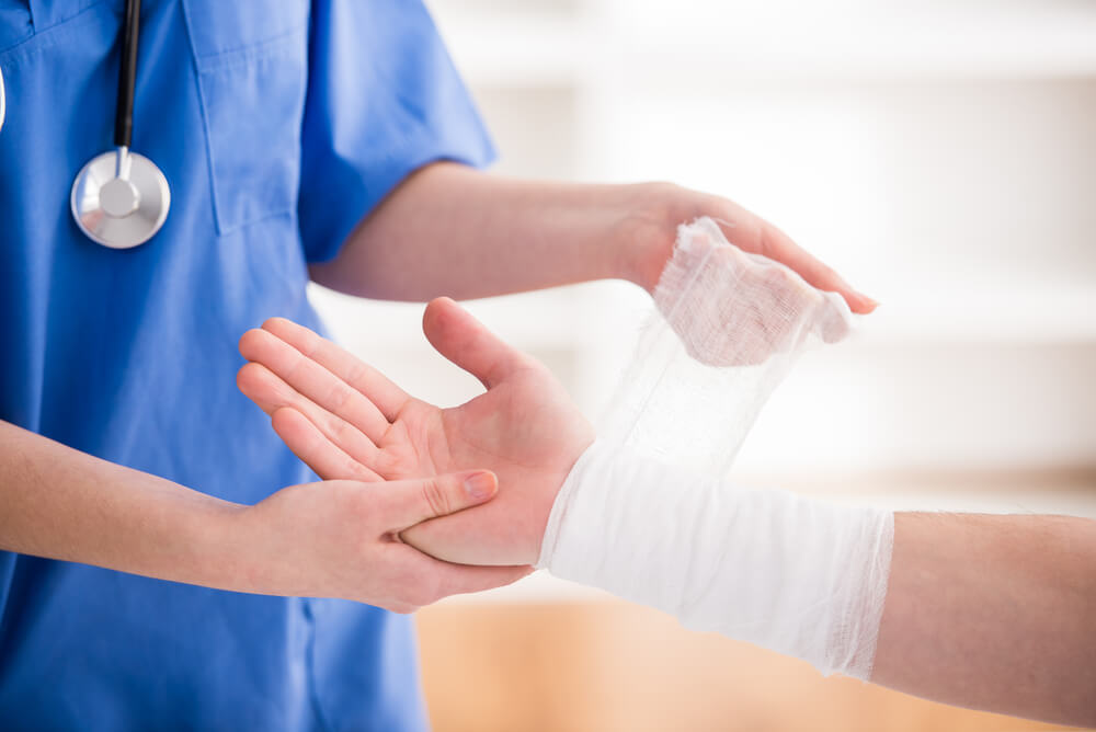 female doctor is bandaging upper limb